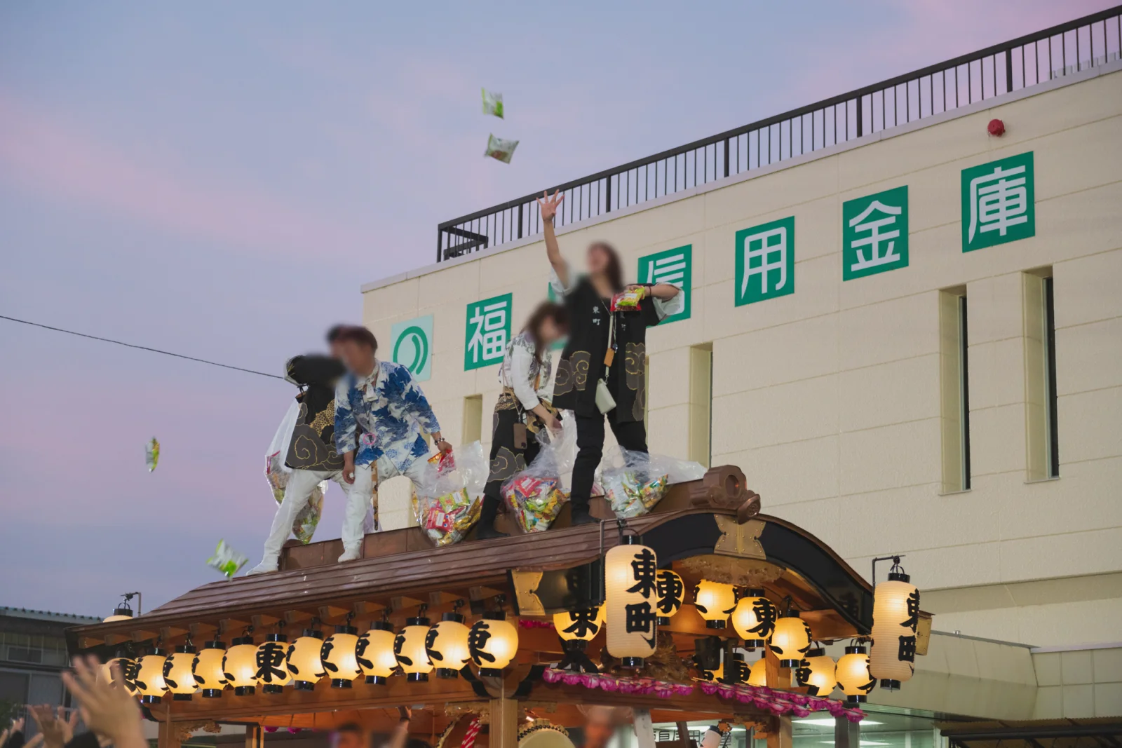 山車の屋根の上からお菓子をまく長岡天王祭のばらまきの場面