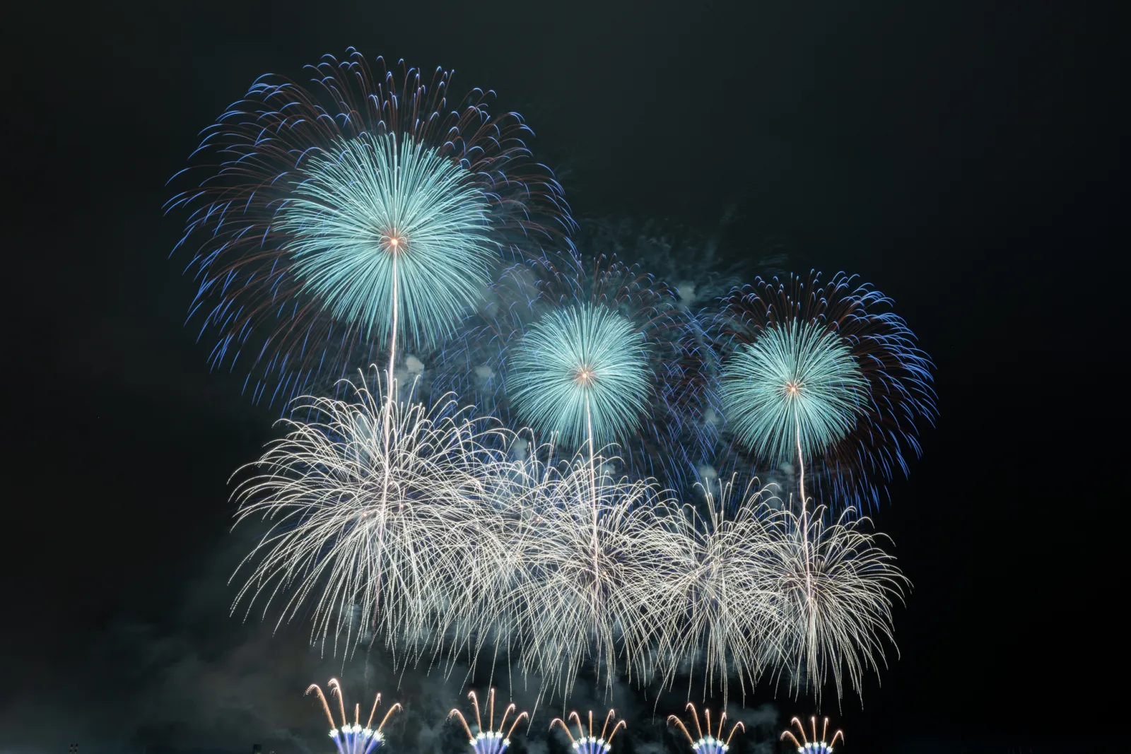 いわき花火大会で青白い大輪の花火が連なって打ち上がる様子