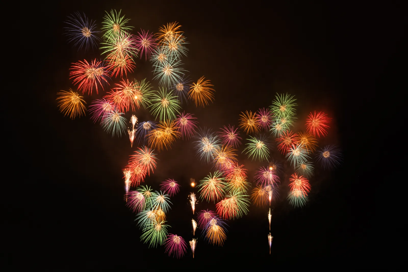 いわき花火大会で赤や緑や黄色の花火が夜空に広がる様子