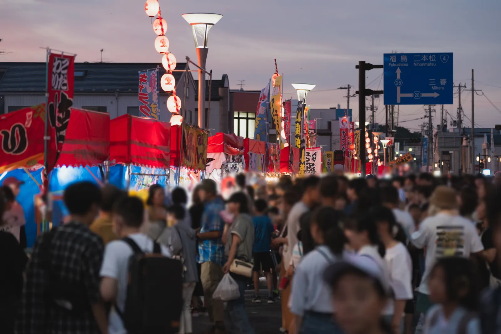本宮市夏まつりの夕方の通りに並ぶ露店と来場者