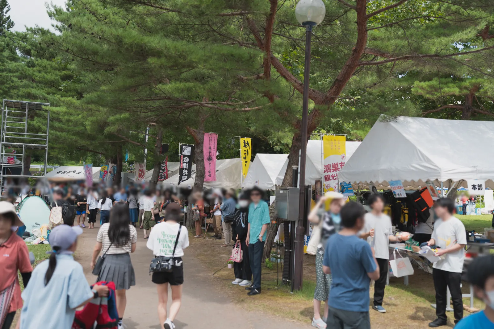 沼沢湖水まつり会場の木陰に並ぶ飲食ブースと来場者